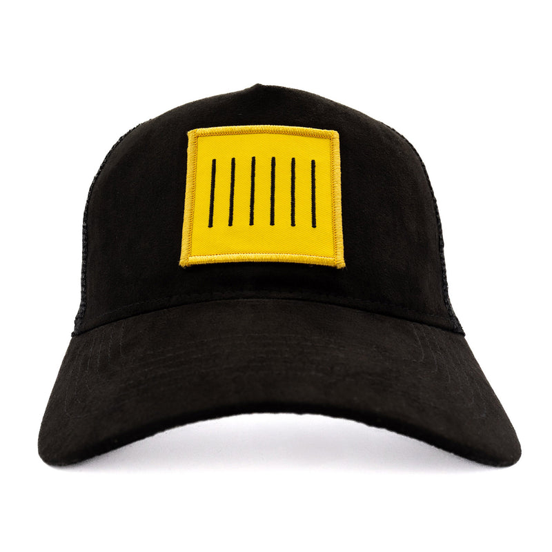 Black trucker cap with a yellow We Are Klank logo patch, front view